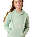 A young woman with freckles and long wavy light brown hair wearing a sage green hoodie with a white horseshoe graphic and the text 'Make your own luck' on the front, set against a plain white background.