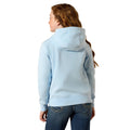 Person wearing a light blue hoodie and jeans on a beige background