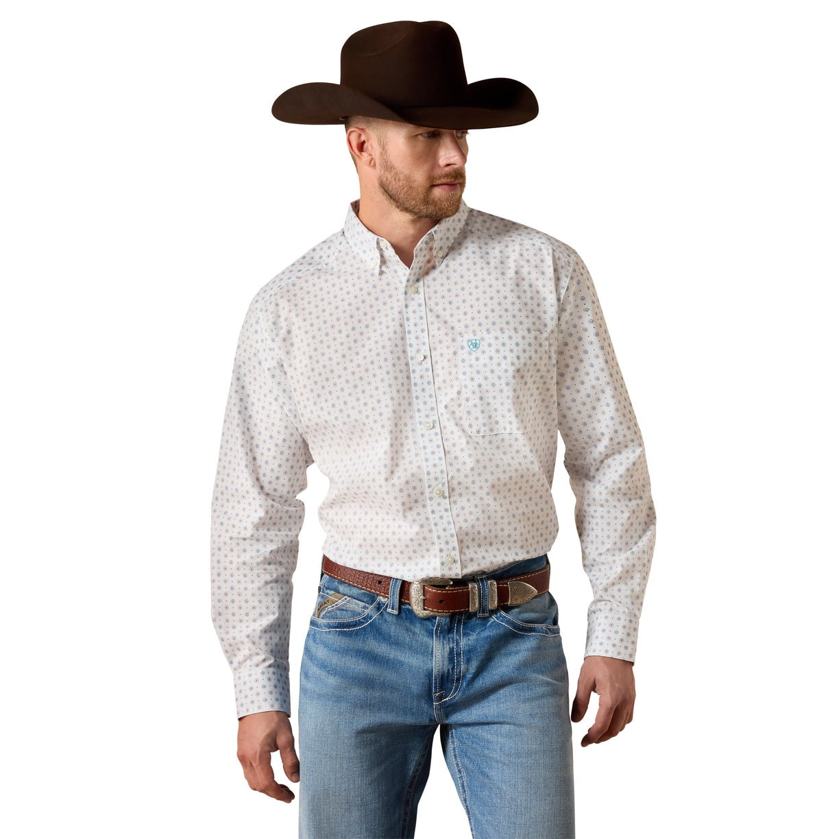A man wearing a white long-sleeve western shirt with a small blue and red geometric pattern, paired with blue jeans, a brown belt, and a dark brown cowboy hat, shown against a plain white background.
