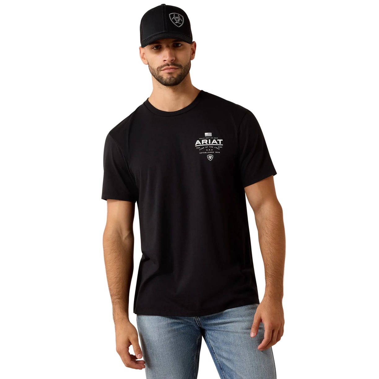Man wearing a black Ariat t-shirt and cap on a beige background