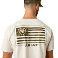 Person wearing a white t-shirt with a camouflage flag design and 'Ariat' branding on the back.