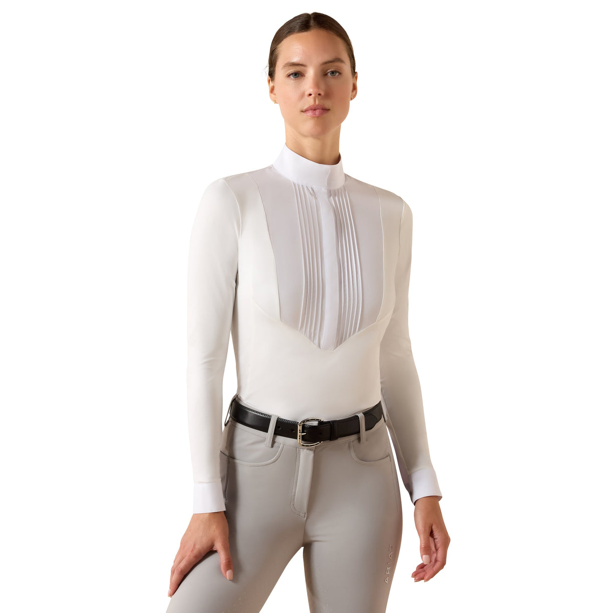 The SolVeil Show Shirt in white with a pleated bib front and mock neck, styled with light grey riding pants.