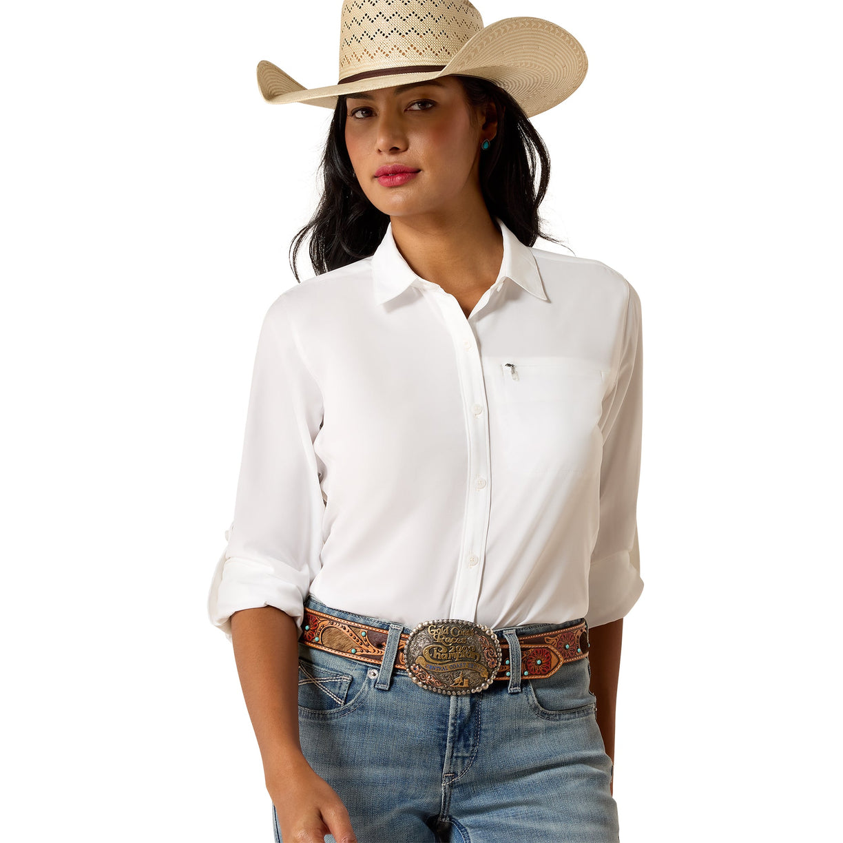 A woman wearing a white long-sleeve button-up shirt, blue jeans, a brown western belt with a large silver buckle, and a beige cowboy hat, photographed against a plain white background.