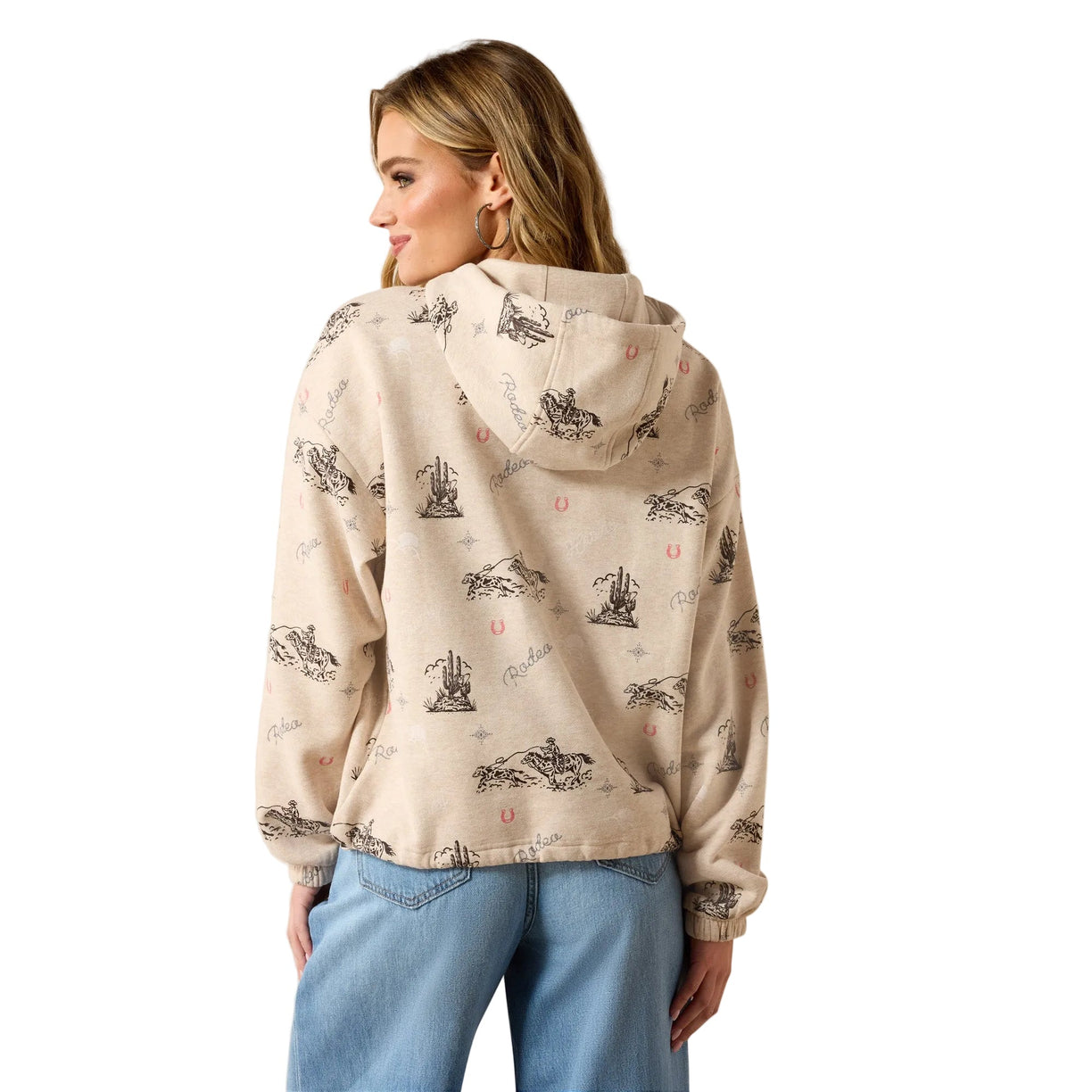 A woman shown from the back wearing a light beige hooded sweatshirt with a black and pink nautical print, paired with light blue jeans, against a solid beige studio background.