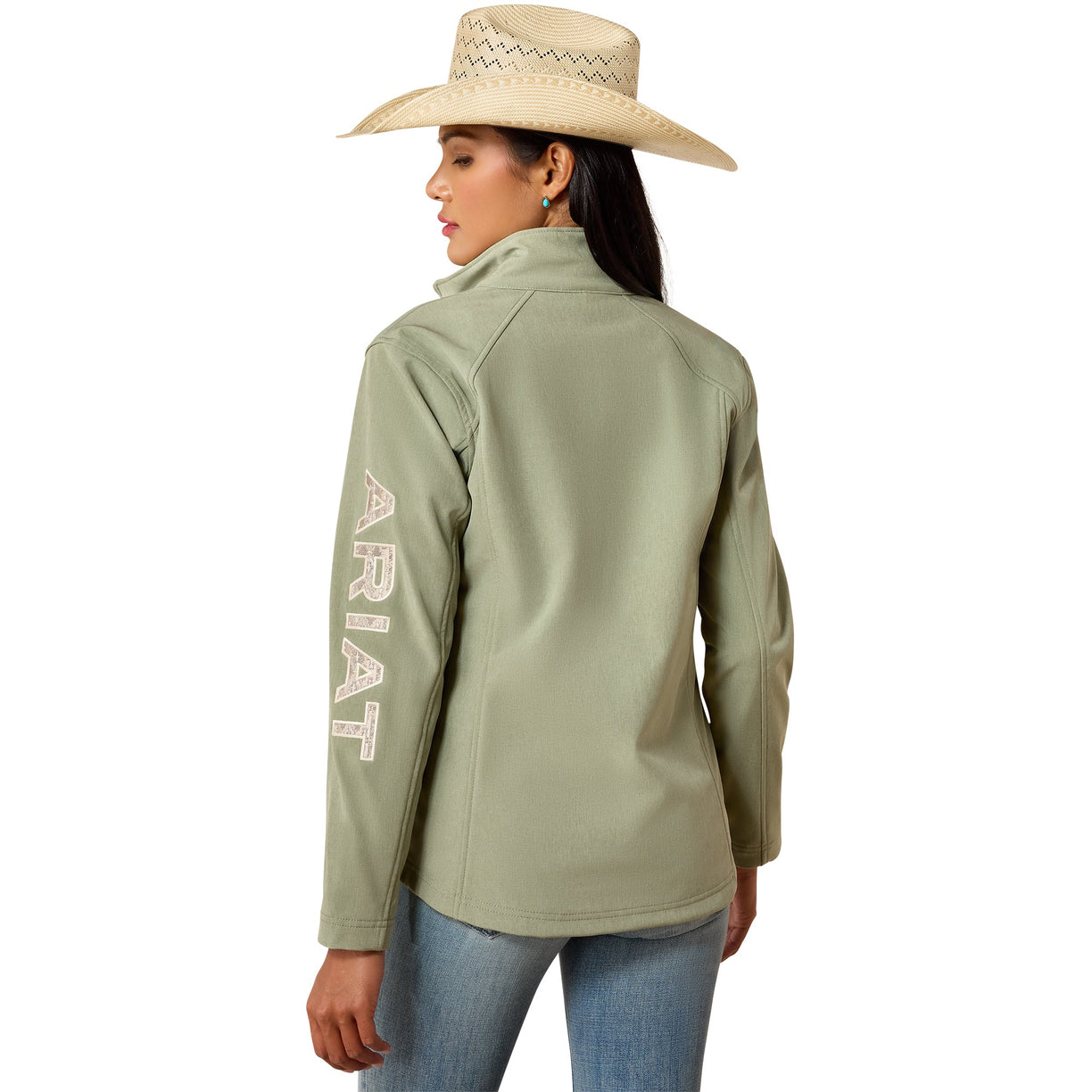 A woman shown from the back wearing an olive green Ariat softshell jacket and a straw cowboy hat, paired with blue jeans, against a plain white background.