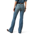 Woman wearing a denim shirt and jeans with a beige hat on a white background