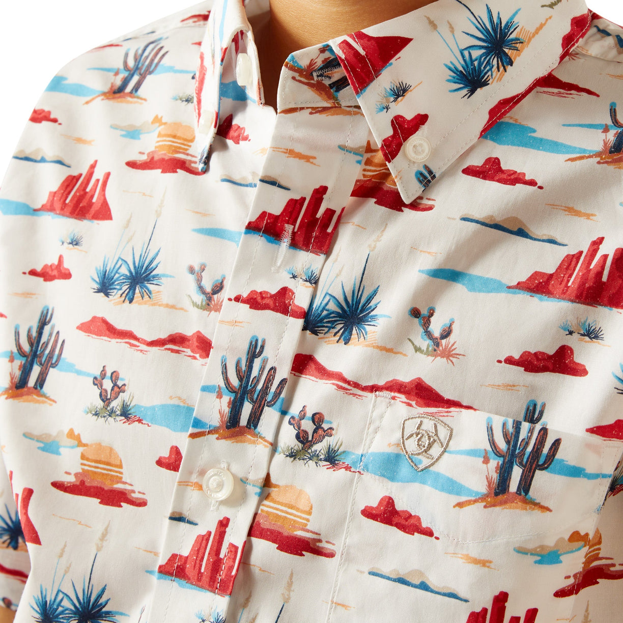 Close-up of a shirt with a colorful desert pattern on a white background