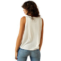 Woman wearing a white sleeveless top and blue jeans on a white background