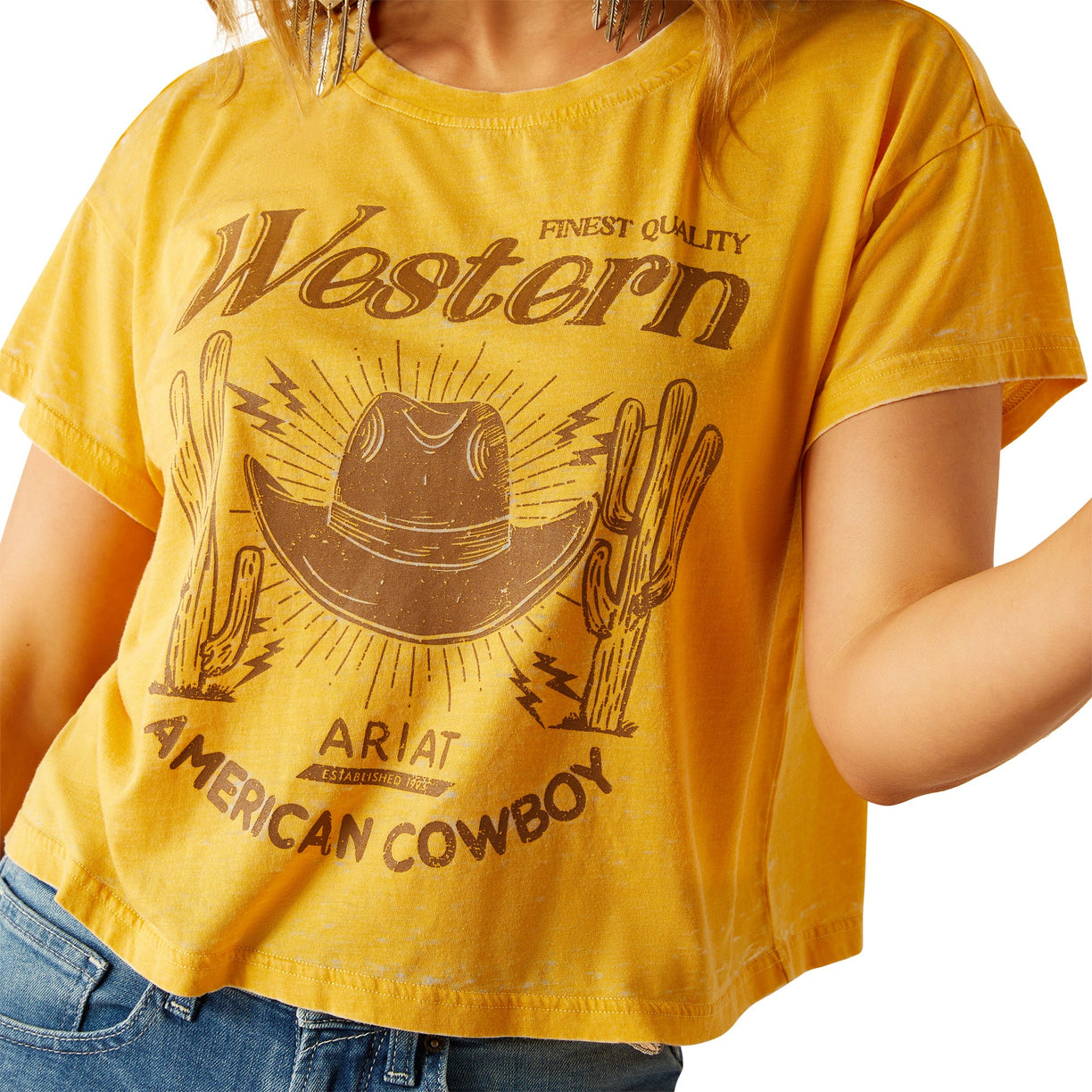 Yellow t-shirt with 'Western American Cowboy' design and Ariat branding on a white background