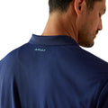 Man wearing a navy blue polo shirt with 'Ariat' logo on a white background