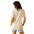 Woman wearing a beige t-shirt and light blue shorts on a white background