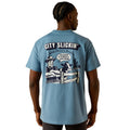 Light blue t-shirt with graphic design and text on the back, worn by a person.