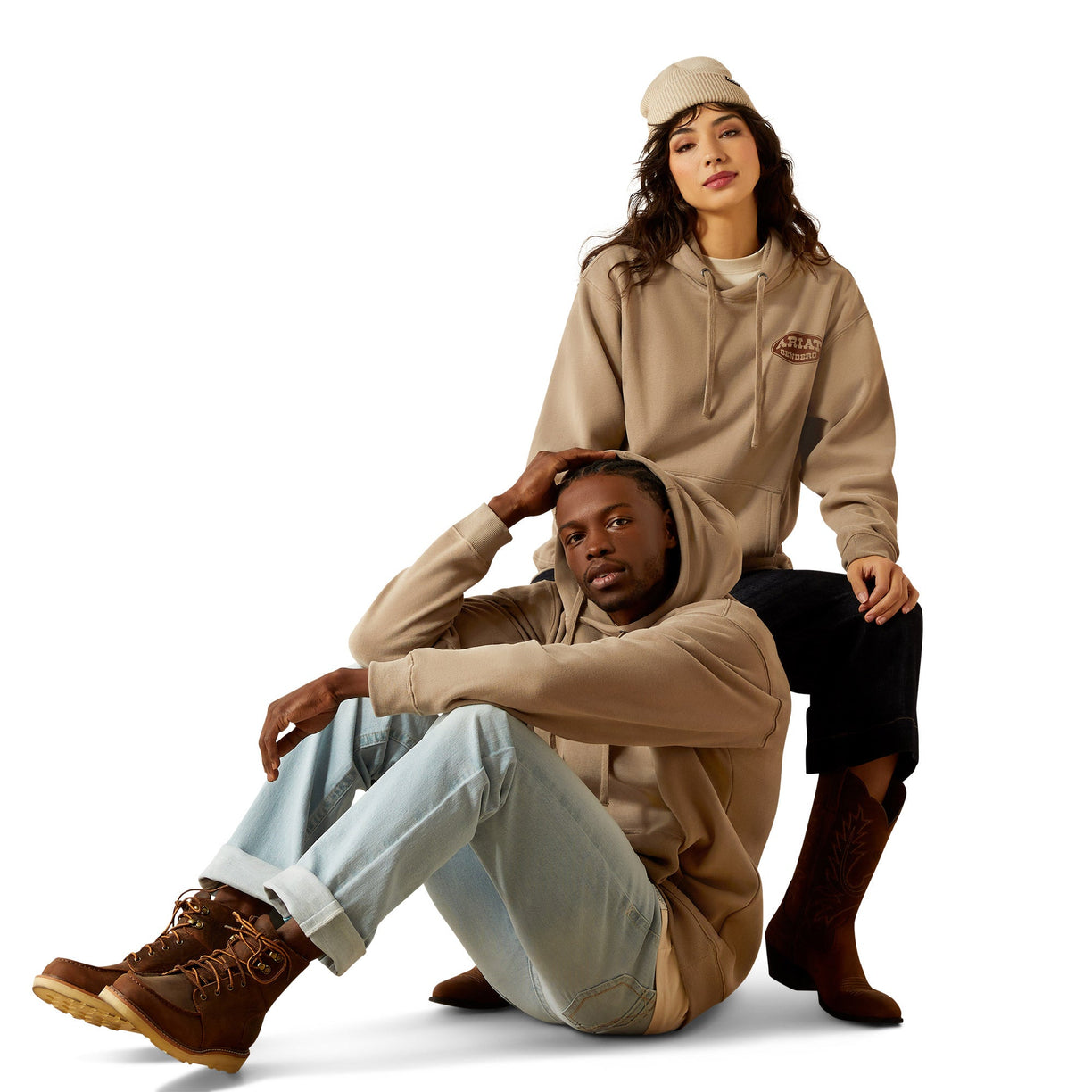 Two people wearing beige hoodies with a visible brand logo on a white background