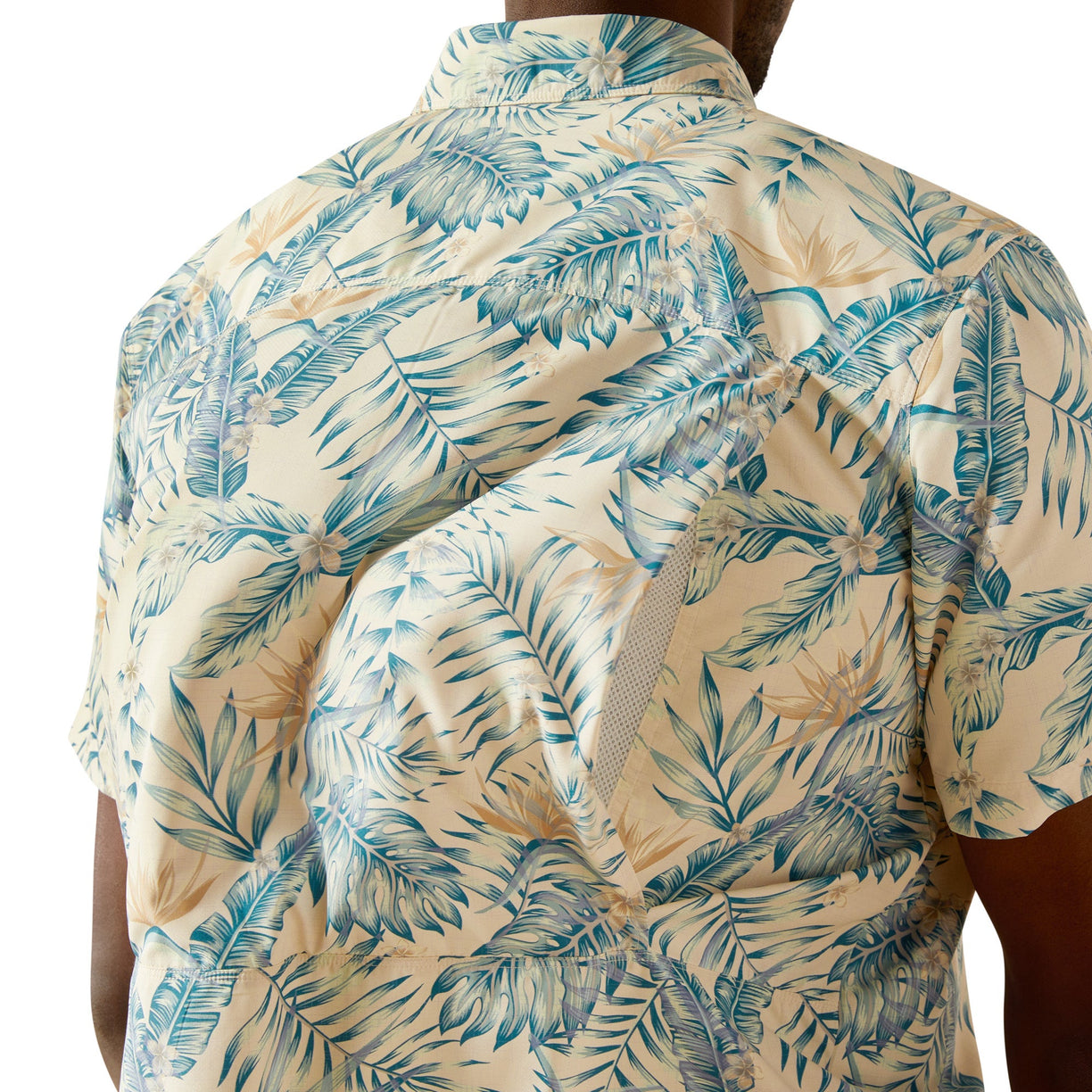 Beige shirt with blue tropical leaf pattern worn by a person