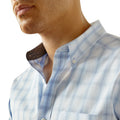 Close-up of a man wearing a blue checkered shirt with a collar.