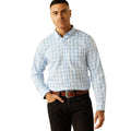 Man wearing a light blue checkered shirt and dark pants on a white background