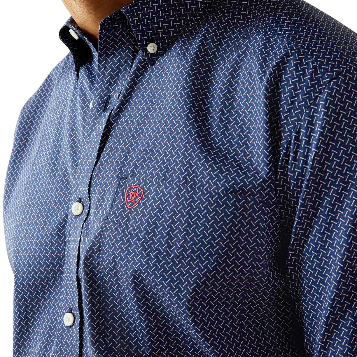 Close-up of a blue patterned shirt with a red logo on a white background
