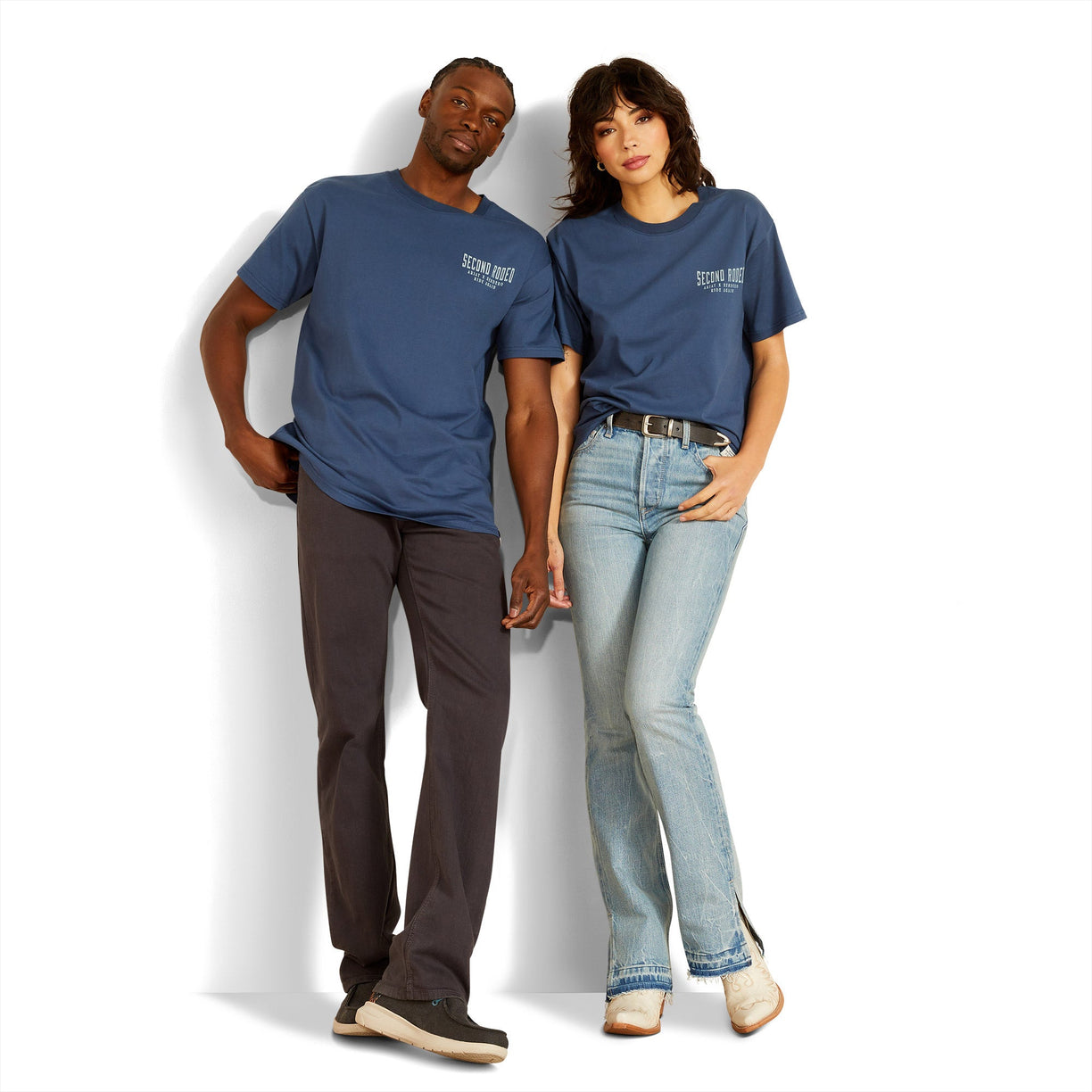 Two people wearing matching blue t-shirts against a white background