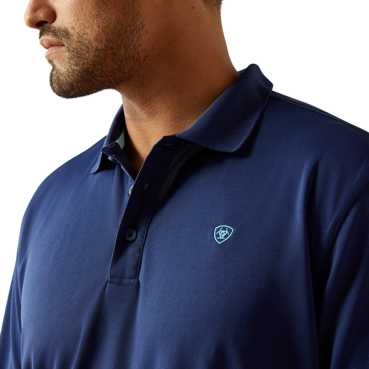 Man wearing a blue polo shirt with a logo on a white background