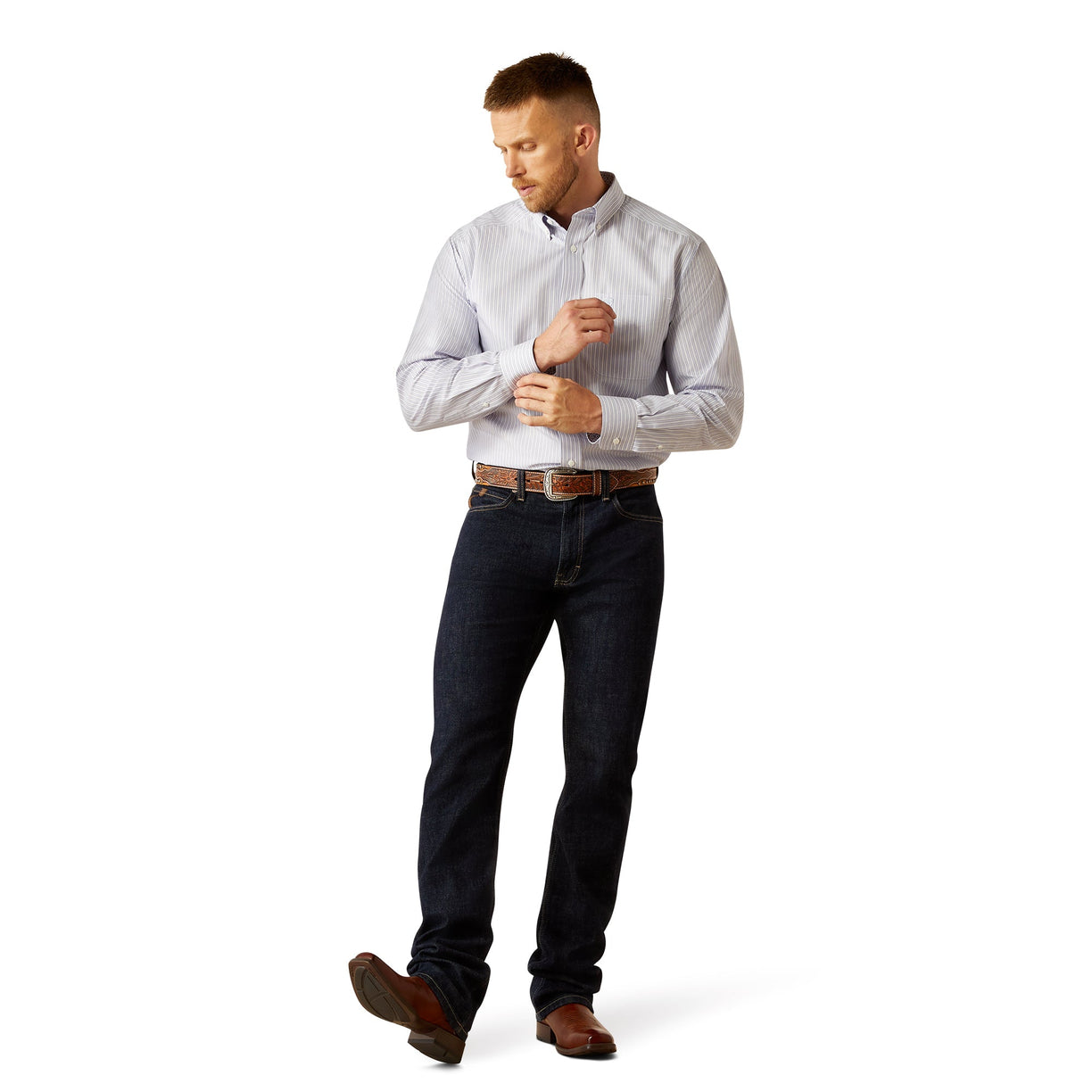 Man wearing a light gray dress shirt and dark jeans on a white background
