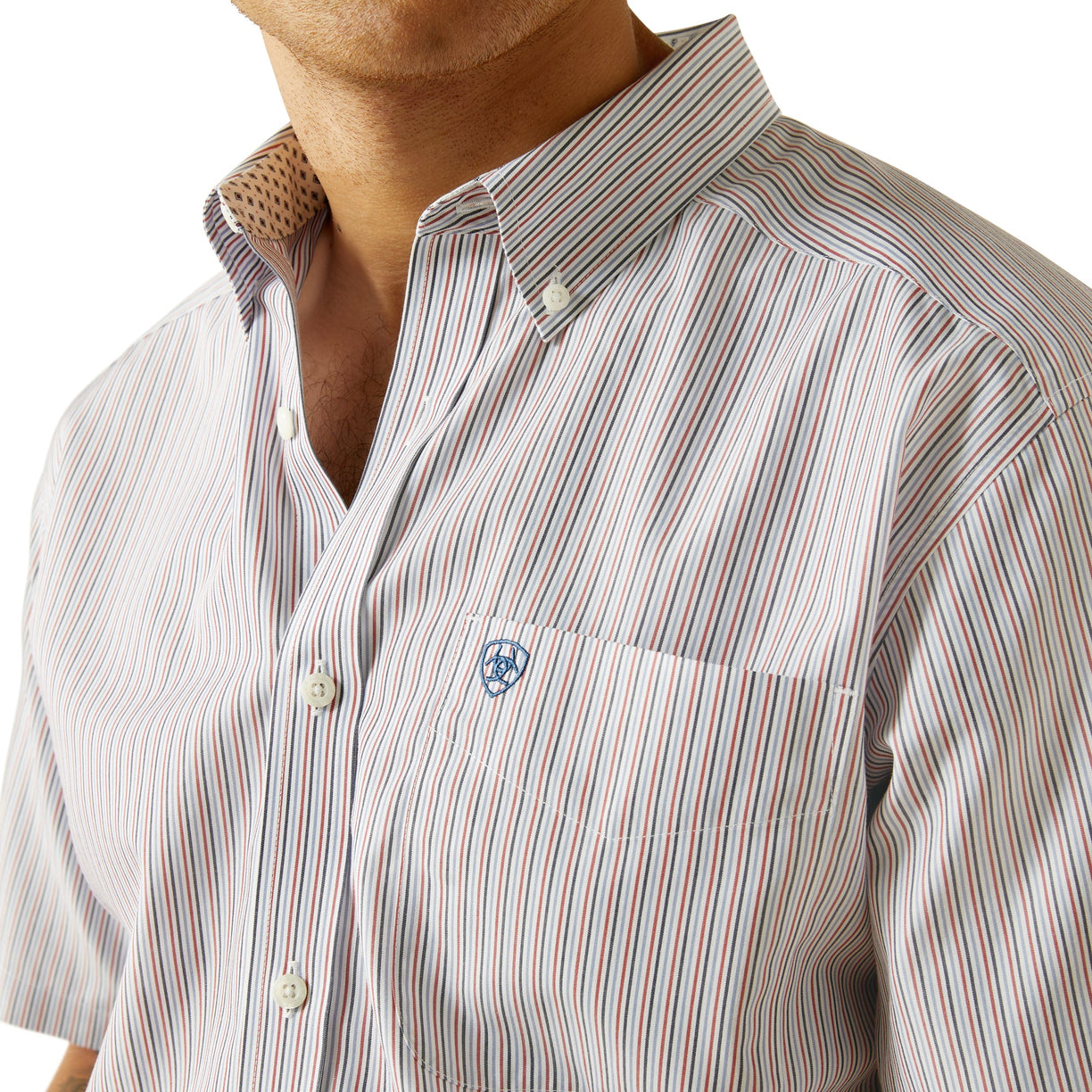 Close-up of a striped shirt with a visible brand logo on a white background