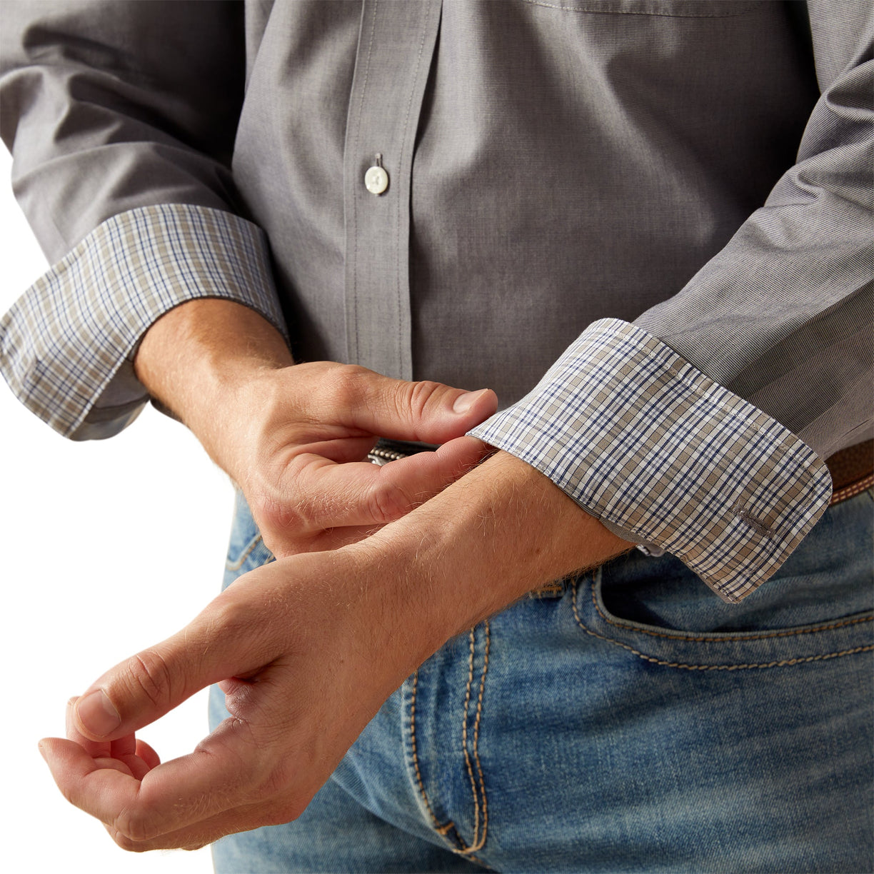 Person wearing a gray shirt with rolled-up sleeves and blue jeans on a white background