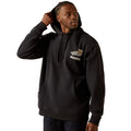 Man wearing a black hoodie with branding on a white background