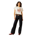 Woman wearing a white t-shirt with a graphic design and dark jeans on a white background